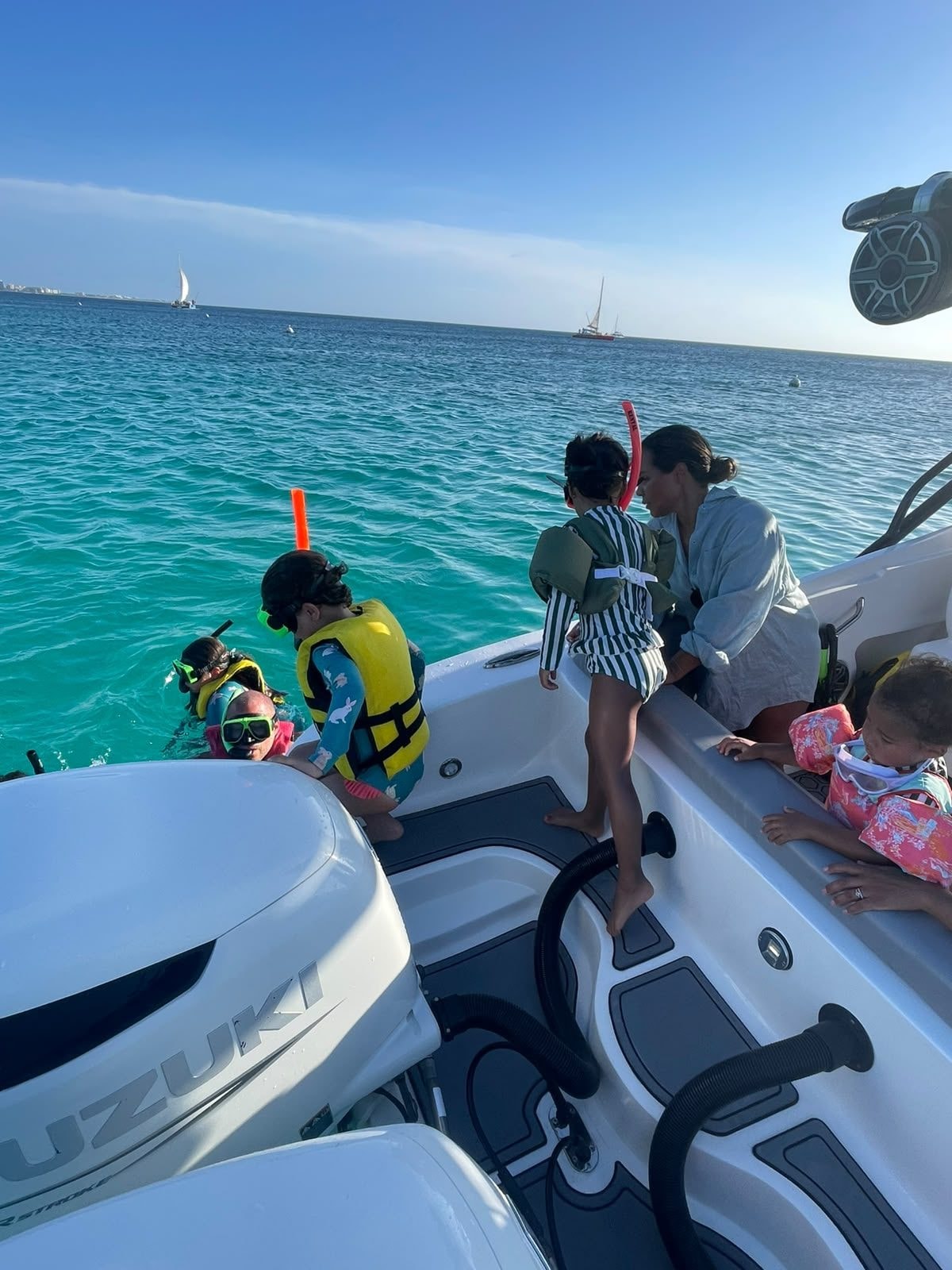 Guests in life vests getting into the water for a snorkel stop
